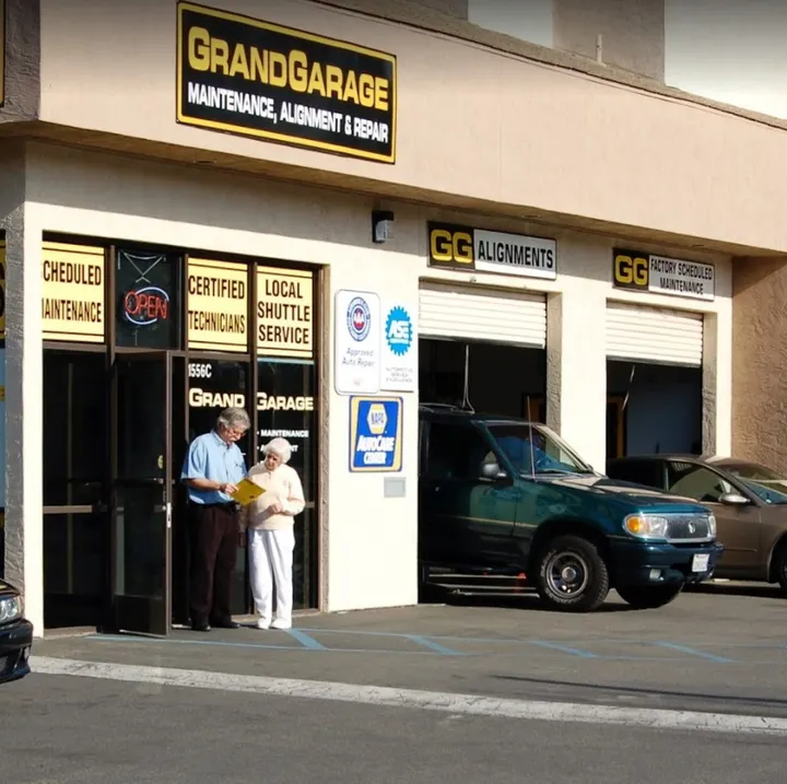 Grand Garage storefront with customers and a green SUV